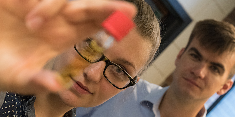 UVM doctoral student Morgan Cousins holds up unusual dye containing Boron. --Photo courtesy of Joshua Brown